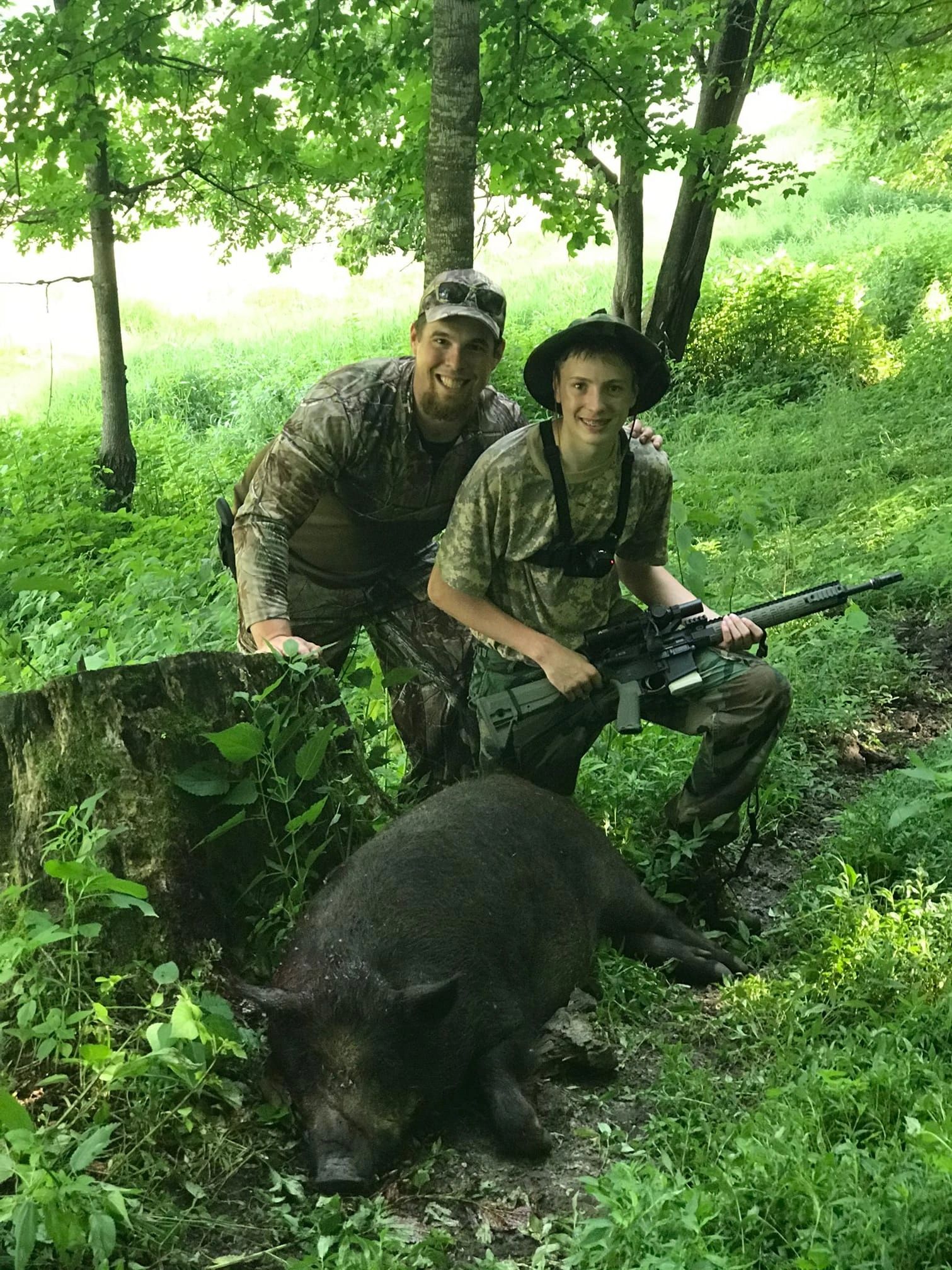 Brothers with their harvested hogs at Scenic View Hunting